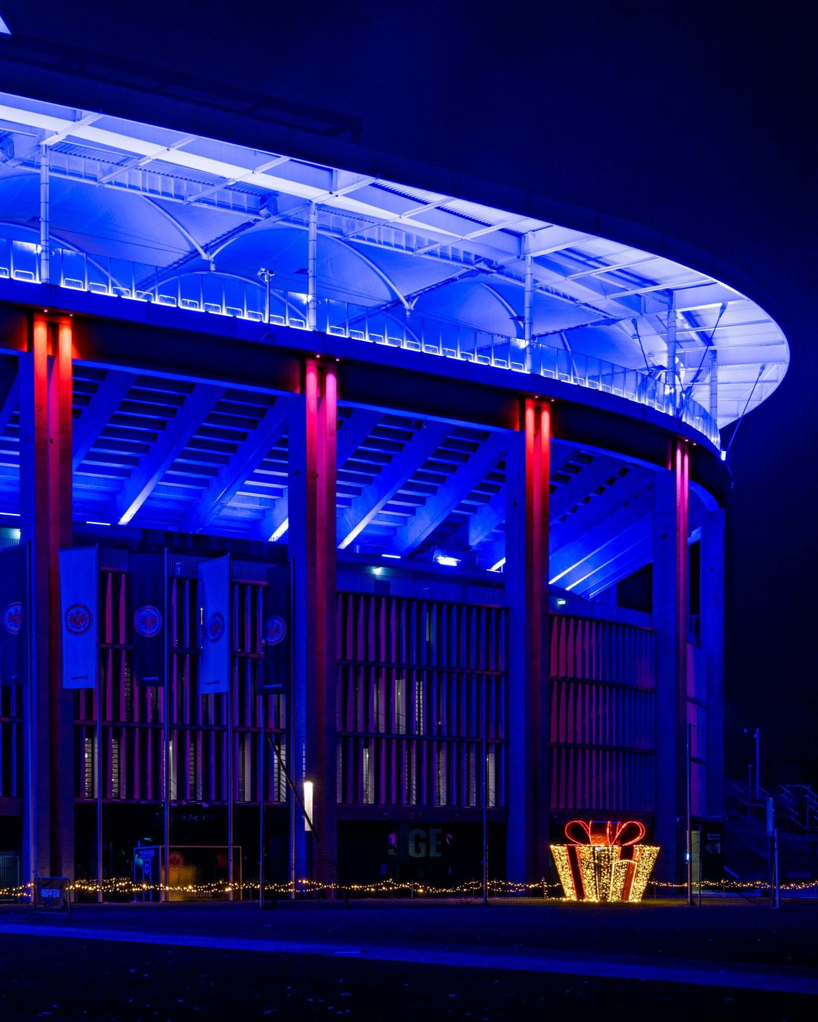 Stunning night view of an illuminated stadium with festive Christmas decorations in Frankfurt, Germany.